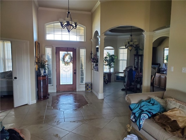 entryway with ornate columns, crown molding, and plenty of natural light