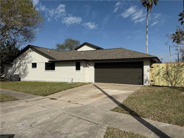 view of front facade with a shingled roof, concrete driveway, an attached garage, a front lawn, and brick siding