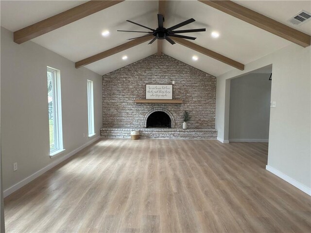 unfurnished living room featuring a brick fireplace, wood-type flooring, vaulted ceiling with beams, and ceiling fan