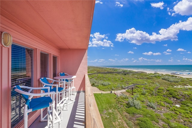 balcony featuring a water view and a beach view