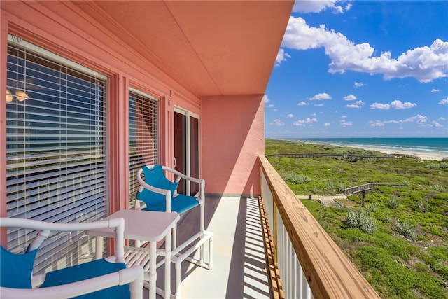 balcony featuring a beach view and a water view