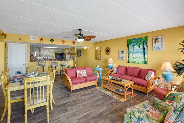 living room with a textured ceiling, dark hardwood / wood-style floors, and ceiling fan