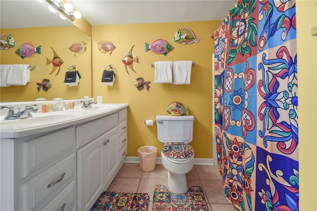 bathroom with tile patterned flooring, vanity, and toilet