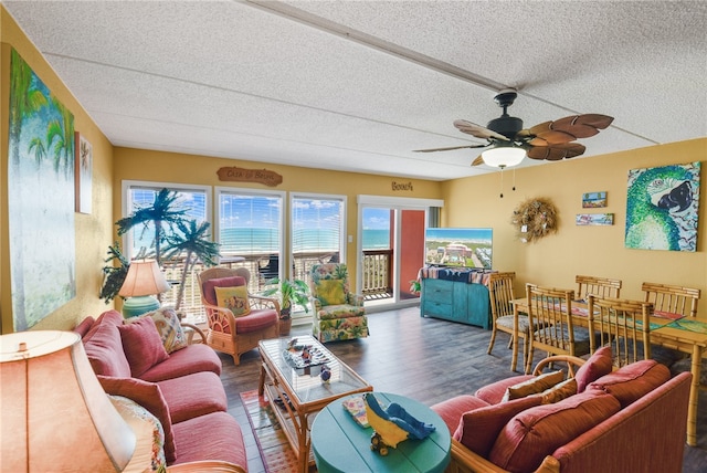 living room with ceiling fan, dark hardwood / wood-style floors, and a textured ceiling