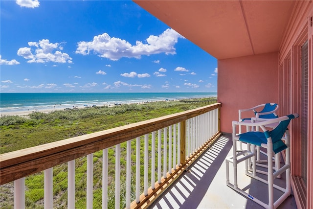 balcony featuring a water view and a beach view