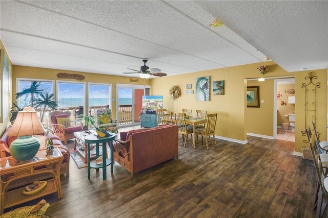 living room featuring dark hardwood / wood-style flooring, a textured ceiling, and ceiling fan