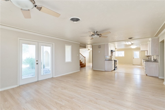 unfurnished living room with french doors, light hardwood / wood-style floors, ceiling fan, and crown molding