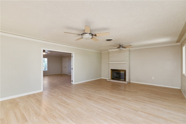 unfurnished living room with ornamental molding, a fireplace, light hardwood / wood-style flooring, and a textured ceiling