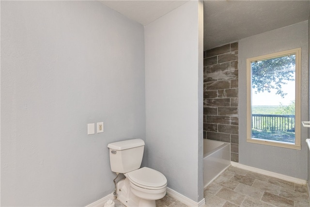 bathroom with toilet and a textured ceiling