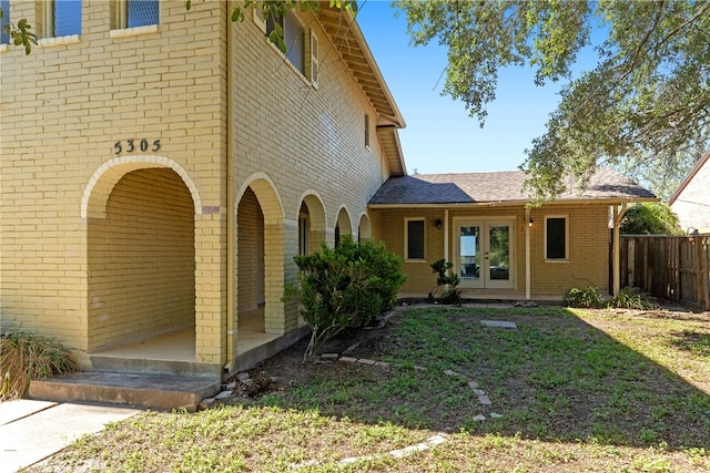 exterior space featuring a yard and french doors