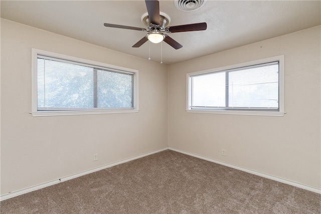 carpeted empty room with plenty of natural light and ceiling fan