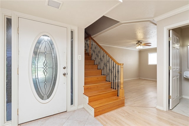 foyer with ceiling fan, light wood-type flooring, and ornamental molding