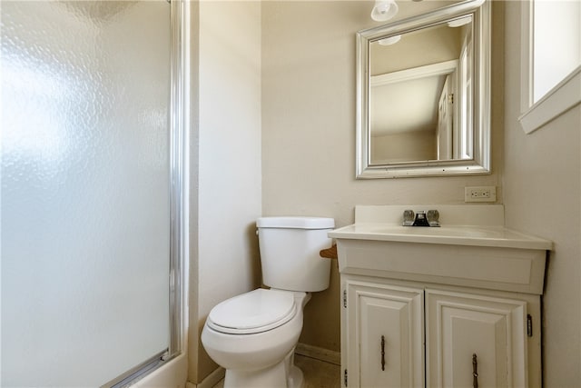 bathroom featuring vanity, toilet, and a shower with door