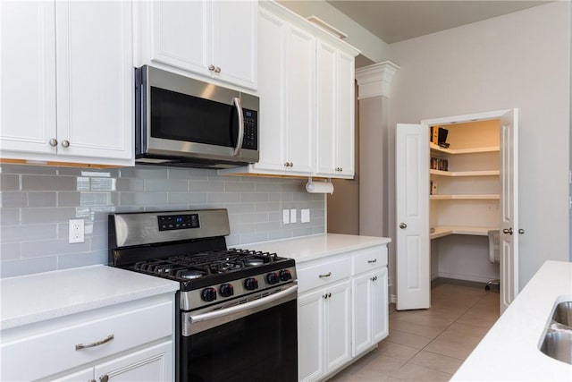 kitchen featuring light stone counters, tasteful backsplash, stainless steel appliances, white cabinets, and light tile patterned floors