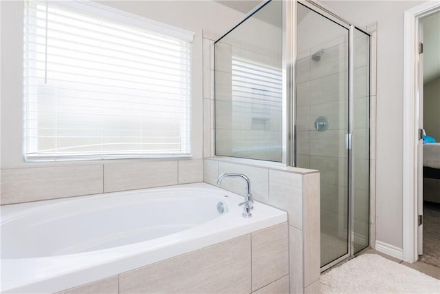 bathroom with a wealth of natural light, a stall shower, and ensuite bath