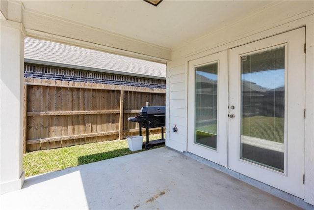 view of patio with area for grilling, french doors, and fence