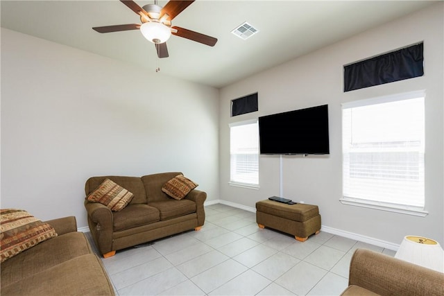 living room featuring light tile patterned floors, baseboards, and ceiling fan