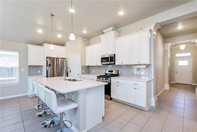 kitchen featuring light tile patterned floors, stainless steel appliances, a wealth of natural light, and a sink