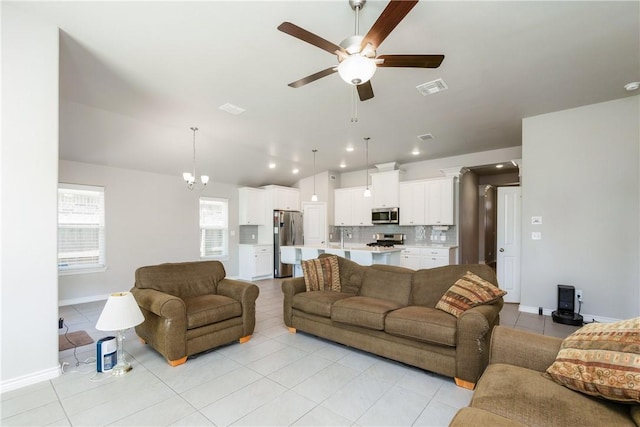 living room with light tile patterned floors, visible vents, lofted ceiling, recessed lighting, and ceiling fan with notable chandelier