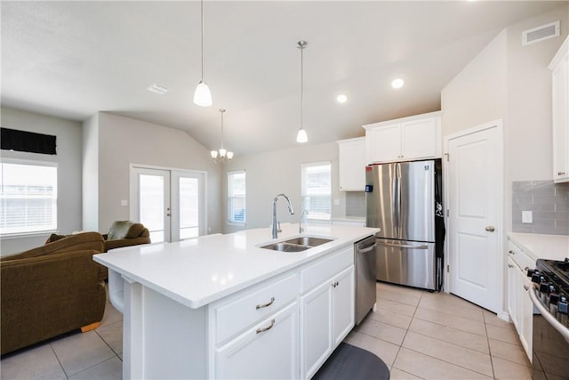 kitchen with visible vents, a sink, open floor plan, appliances with stainless steel finishes, and light countertops