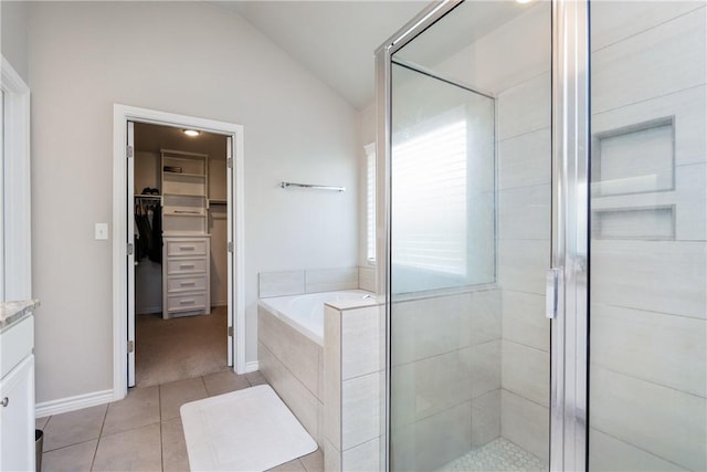 bathroom featuring tile patterned flooring, a shower stall, and lofted ceiling