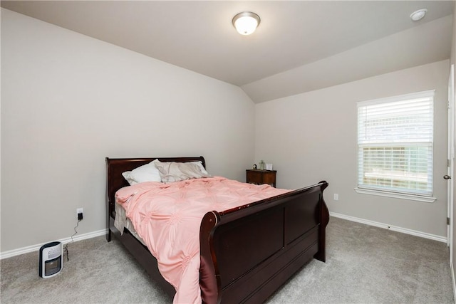 bedroom featuring lofted ceiling, baseboards, and light carpet