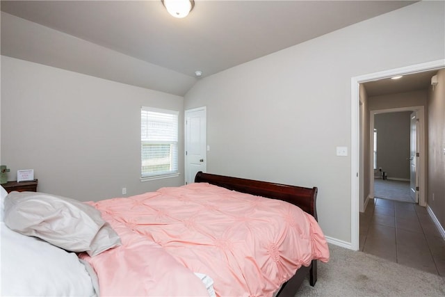 carpeted bedroom with tile patterned flooring, baseboards, and lofted ceiling