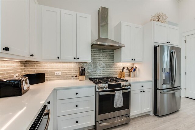 709 Sunrise Ave, Port Aransas, TX 78373 - kitchen featuring decorative backsplash, stainless steel appliances, light countertops, and wall chimney range hood