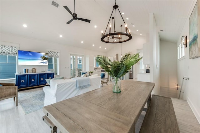 709 Sunrise Ave, Port Aransas, TX 78373 - dining room featuring ceiling fan with notable chandelier, plenty of natural light, light wood-style floors, and visible vents