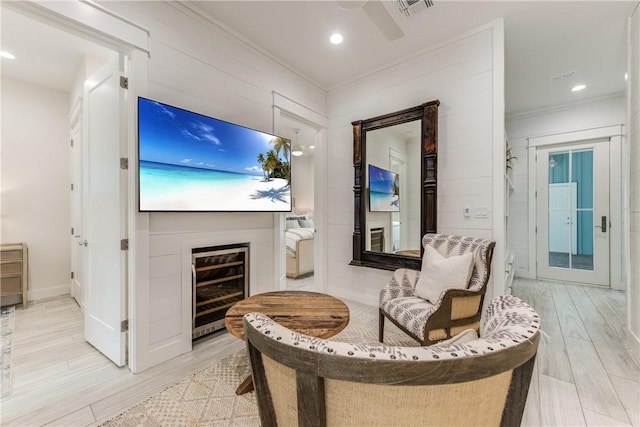 709 Sunrise Ave, Port Aransas, TX 78373 - sitting room featuring beverage cooler, visible vents, light wood-style flooring, and crown molding