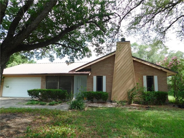 1408 Rose Dr, Alice, TX 78332 - view of front facade with brick siding, a garage, a chimney, driveway, and metal roof