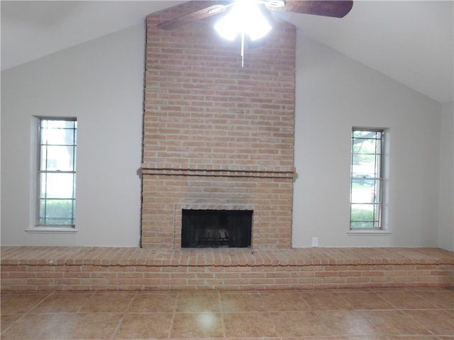 unfurnished living room with a fireplace, ceiling fan, a healthy amount of sunlight, and vaulted ceiling