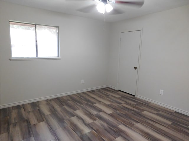 spare room featuring dark wood-type flooring and ceiling fan