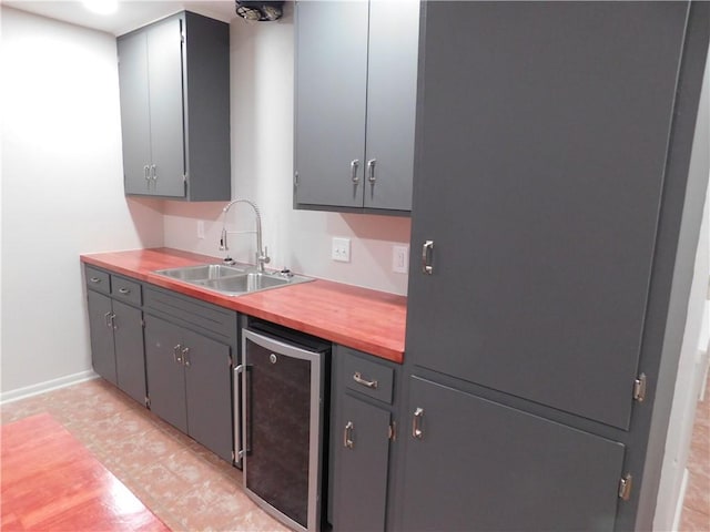 1408 Rose Dr, Alice, TX 78332 - kitchen featuring wine cooler, a sink, baseboards, and gray cabinets