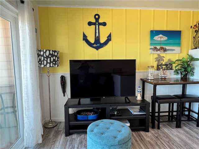 living room with hardwood / wood-style flooring and crown molding