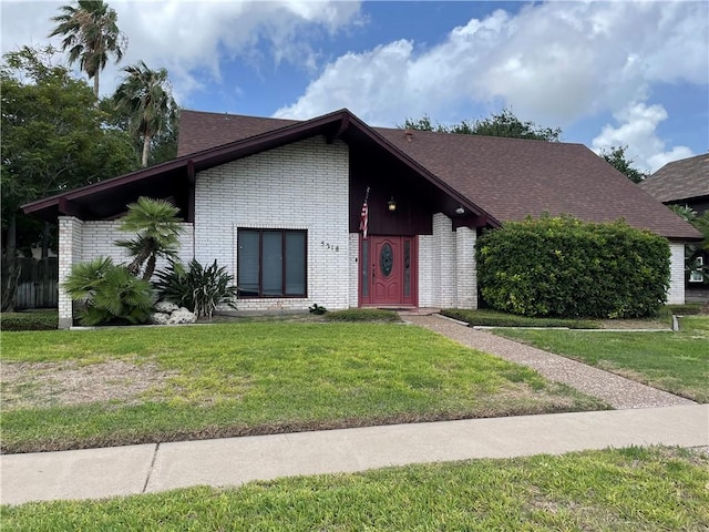 5218 Wooldridge Rd, Corpus Christi, TX 78413 - view of front facade featuring brick siding, a front yard, and a shingled roof