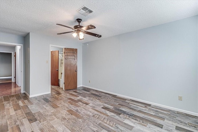 unfurnished bedroom featuring hardwood / wood-style flooring, ceiling fan, and a textured ceiling