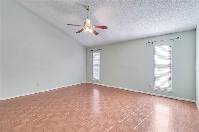 empty room featuring light parquet flooring, lofted ceiling, a textured ceiling, and ceiling fan