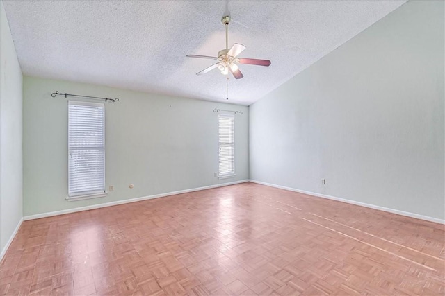 unfurnished room with a textured ceiling, vaulted ceiling, light parquet flooring, and ceiling fan