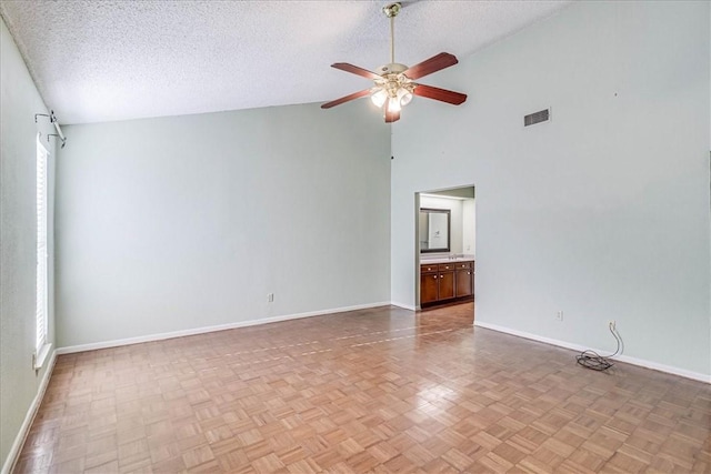 unfurnished room featuring ceiling fan, light parquet flooring, high vaulted ceiling, and a textured ceiling