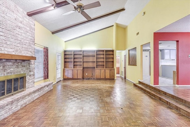 unfurnished living room with ceiling fan, high vaulted ceiling, a textured ceiling, a brick fireplace, and beamed ceiling