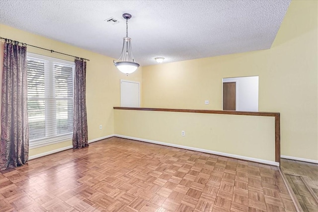 unfurnished room with parquet flooring and a textured ceiling