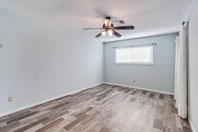 spare room featuring hardwood / wood-style flooring, a textured ceiling, and ceiling fan