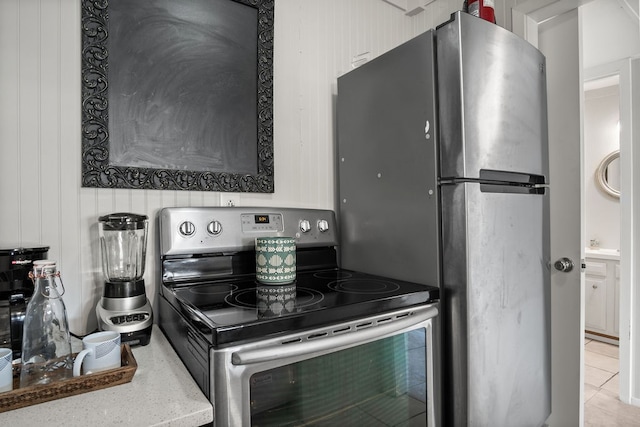 kitchen with stainless steel electric range oven and light tile patterned flooring