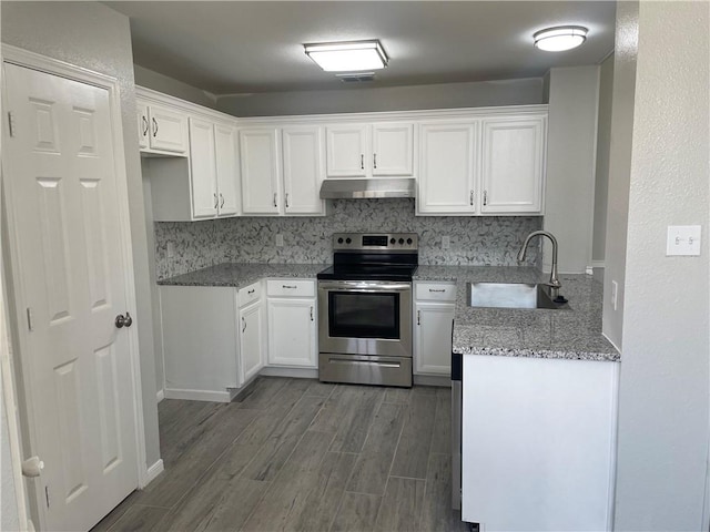 kitchen featuring backsplash, sink, electric range, light stone counters, and white cabinetry