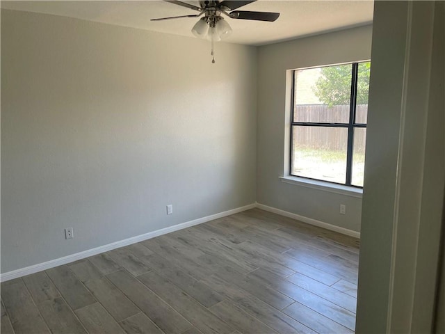 spare room with wood-type flooring, a wealth of natural light, and ceiling fan