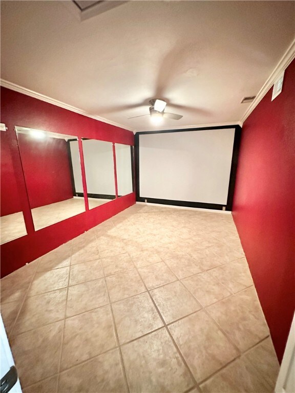 tiled cinema with ceiling fan and ornamental molding