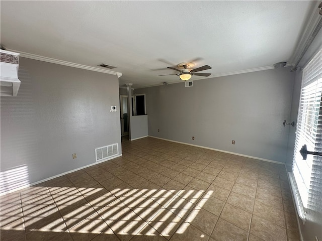 tiled spare room featuring ceiling fan, ornate columns, and ornamental molding