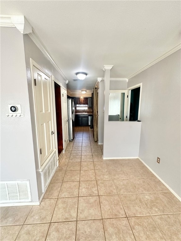 hallway with light tile patterned floors and ornamental molding