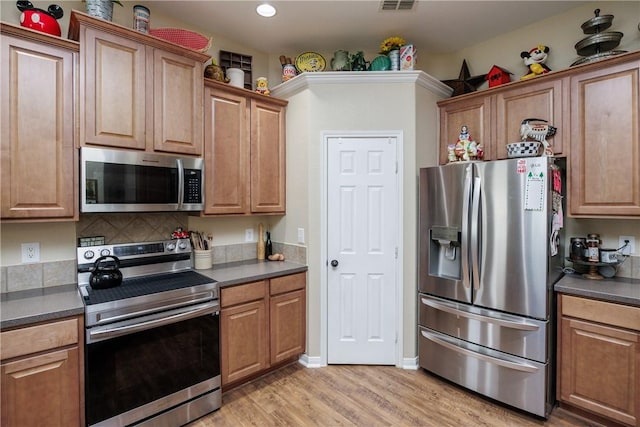 6005 Tapestry Dr, Corpus Christi, TX 78414 - kitchen featuring appliances with stainless steel finishes, dark countertops, light wood-type flooring, backsplash, and recessed lighting